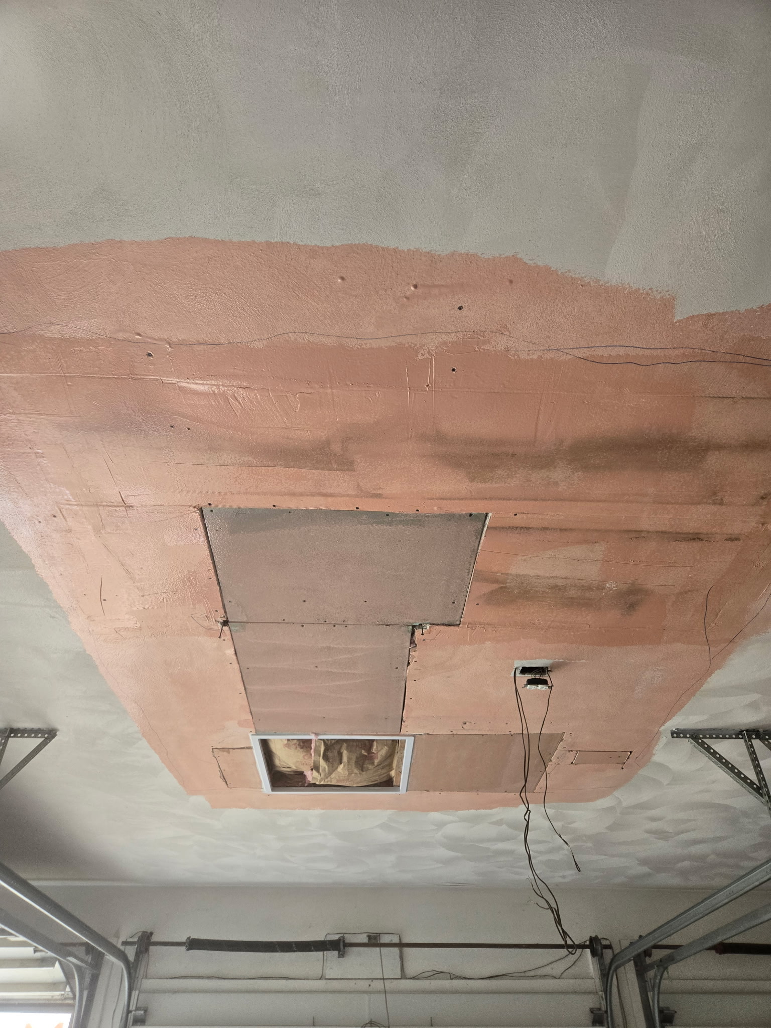 Ceiling repair with new board fitted and base coat applied over the patched area