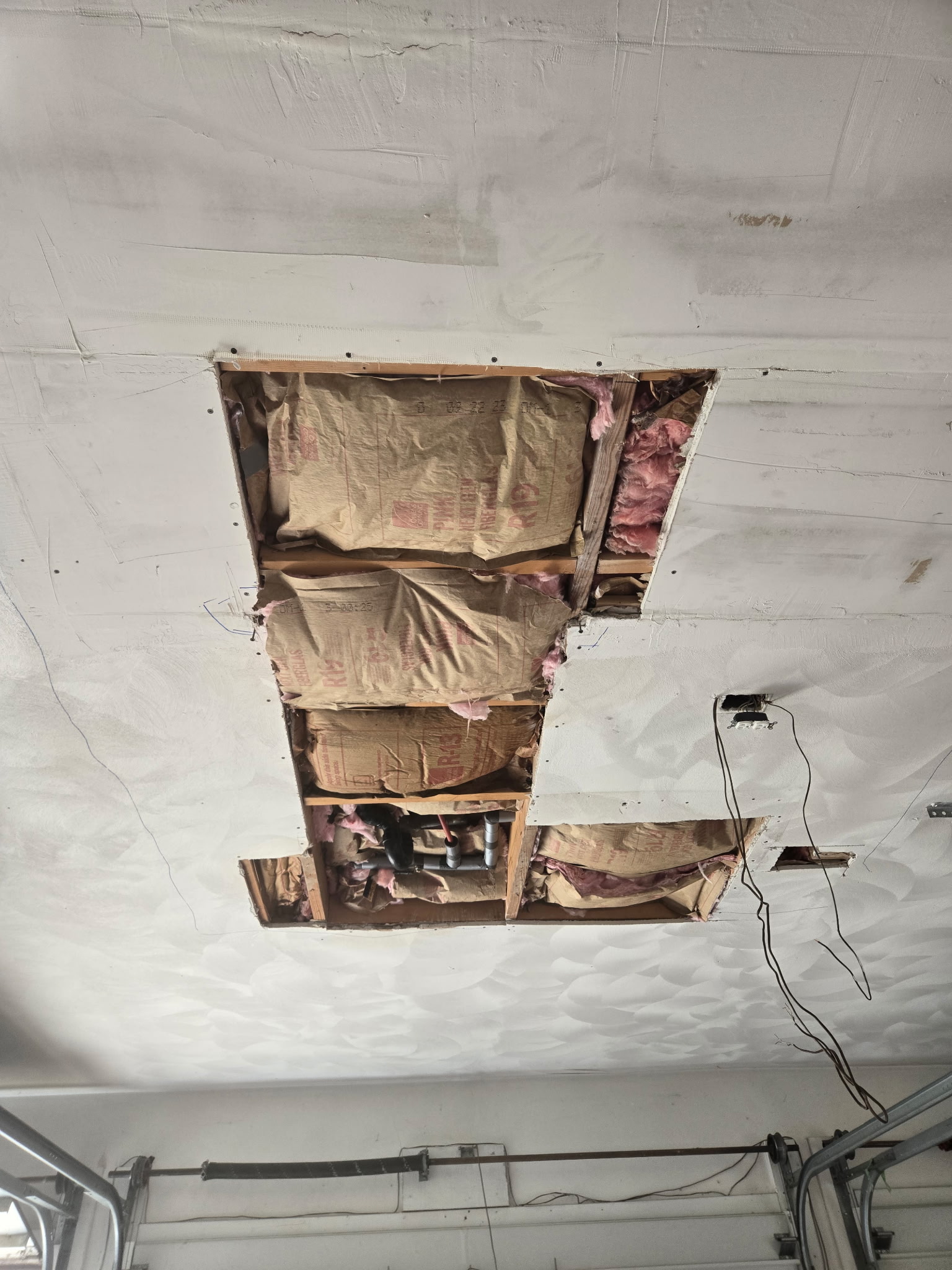 Ceiling cut back to sound material, joists and pipework exposed