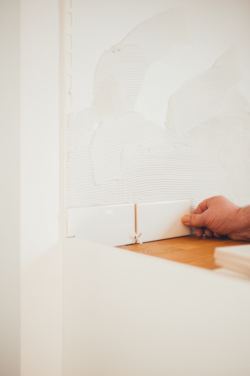 Person smoothing a wall surface during skim coat plastering work