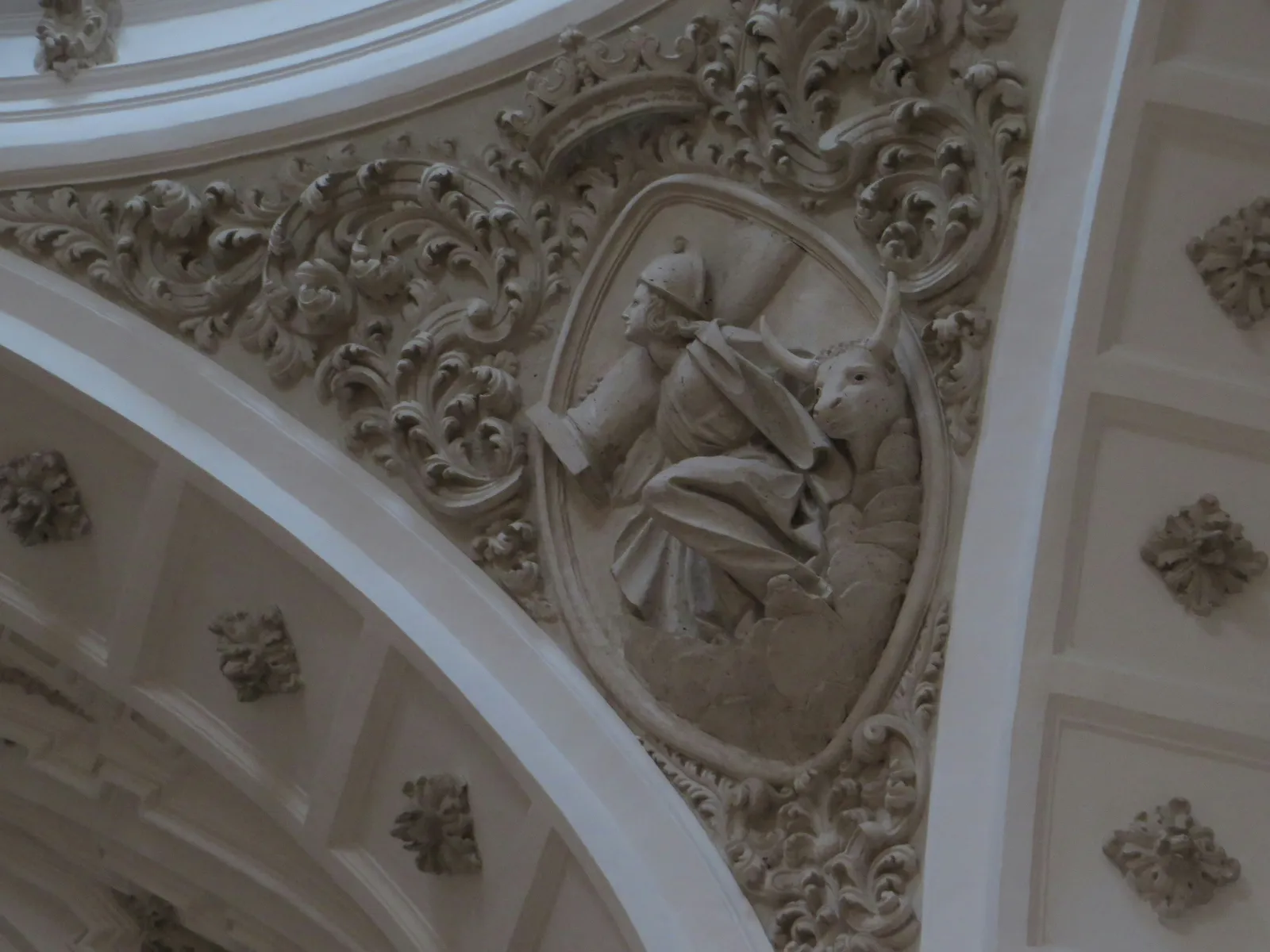 Ornamental plaster relief and scrollwork on a vaulted ceiling